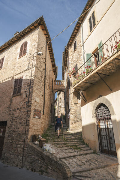 A young man is walking on a stairway in Spello. Perugia province, Umbria, Italy, Europe