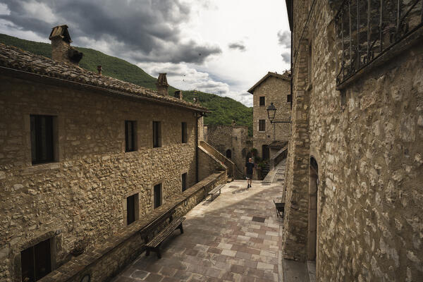 A young man is walking into the village of Vallo di Nera. Perugia province, Umbria, Italy, Europe