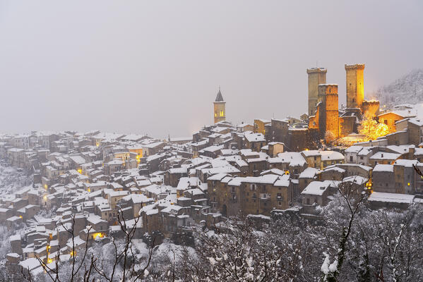 The winter panoramic illuminated medieval village of Pacentro with the castle and bell tower and snow covered house, Pacentro municipality, Maiella national park, L’aquila province, Abruzzo, Italy