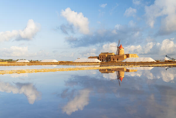 Windmill reflection in the water of the salt flats, saline dello Stagnone, Marsala, Trapani province, Sicily, Italy