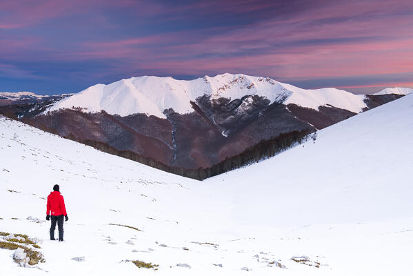 Man admires snow covered Viglio mountain at the dusk, Apennines, Simbruini regional park, Frosinone province, Latium, Italy