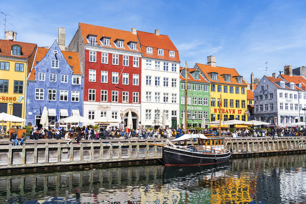 View of the colourful buildings and an old ship along Nyhavn canal with reflection in the water, Copenhagen, Hovedstaden Denmark, Europe