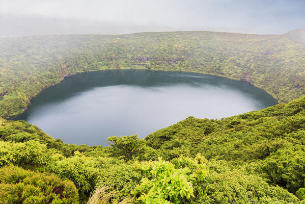 View from above of the Caldeira Negra among fog, Miradouro Lagoa Negra e Lagoa Comprida, Reserva Florestal Natural Morro Alto e Pico da Se, Lajes das Flores municipality, Flores Island (Ilha das Flores), Azores archipelago, Portugal, Europe