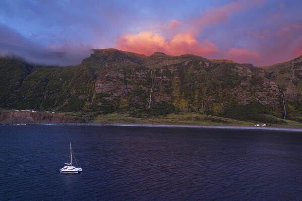 Faja Grande bay with Poco do Bacalhau waterfall and boat at dusk, Faja Grande, Lajes das Flores, Flores Island (Ilha das Flores), Azores archipelago, Portugal, Europe