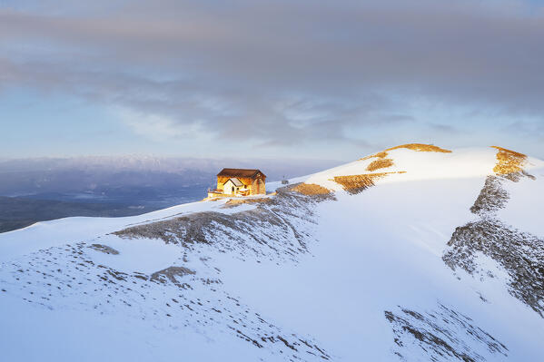 Aerial view of the Duca degli Abruzzi hut during spring thaw at sunrise, Campo Imperatore, Gran Sasso and Laga Mountains National Park, L'Aquila province, Abruzzo, Italy, Europe