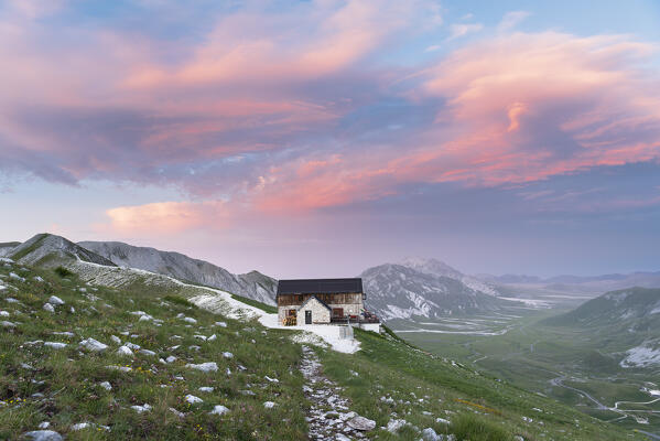 Duca degli Abruzzi mountain hut with pink sky at dusk, Campo Imperatore, Gran Sasso and Laga Mountains National Park, L'Aquila province, Abruzzo, Italy, Europe