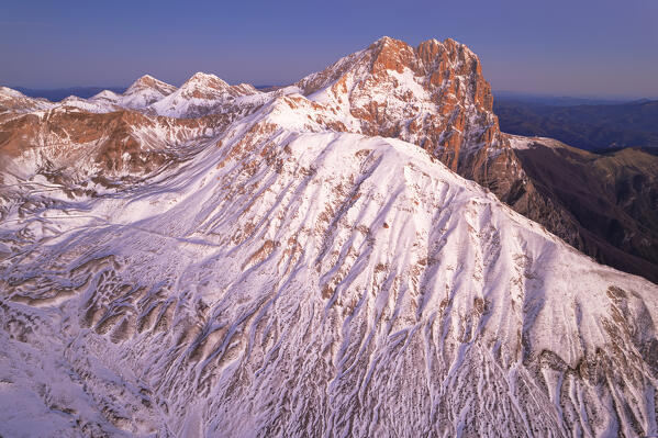 Aerial winter view of the snowy massif of Gran Sasso (Corno Grande) at dawn, Campo Imperatore, Gran Sasso e Monti della Laga National Park, L'Aquila province, Abruzzo region, central Italy, Italy, Europe