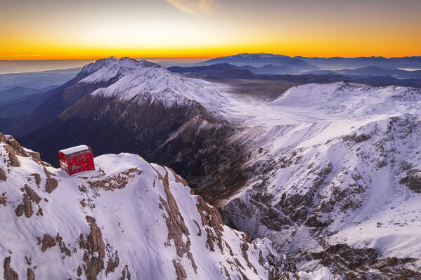 Winter view of Bafile hut (bivacco Bafile), Campo Imperatore plateau and Gran Sasso mountain range with snow at sunrise, Campo Imperatore, Gran Sasso e Monti della Laga National Park, L'Aquila province, Abruzzo region, central Italy, Italy, Europe