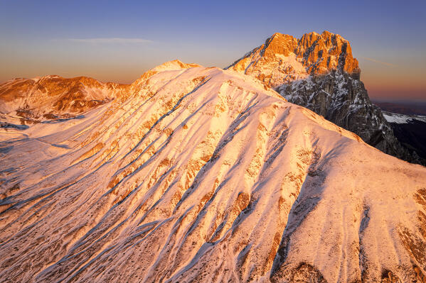 Aerial winter view of the snowy massif of Gran Sasso (Corno Grande) and Aquila mountain at sunrise, Campo Imperatore, Gran Sasso e Monti della Laga National Park, L'Aquila province, Abruzzo region, central Italy, Italy, Europe