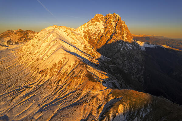 Aerial winter view of the massif of Gran Sasso (Corno Grande) and Aquila mountain covered from snow at sunrise, Campo Imperatore, Gran Sasso e Monti della Laga National Park, L'Aquila province, Abruzzo region, central Italy, Italy, Europe
