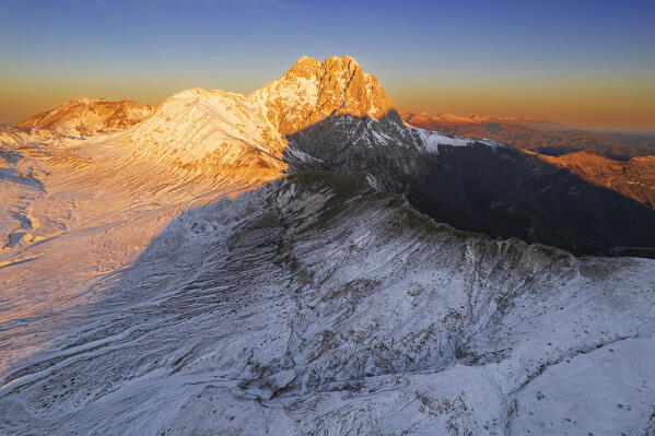 Aerial winter view of the massif of Gran Sasso (Corno Grande) and Aquila mountain covered from snow at sunrise, Campo Imperatore, Gran Sasso e Monti della Laga National Park, L'Aquila province, Abruzzo region, central Italy, Italy, Europe