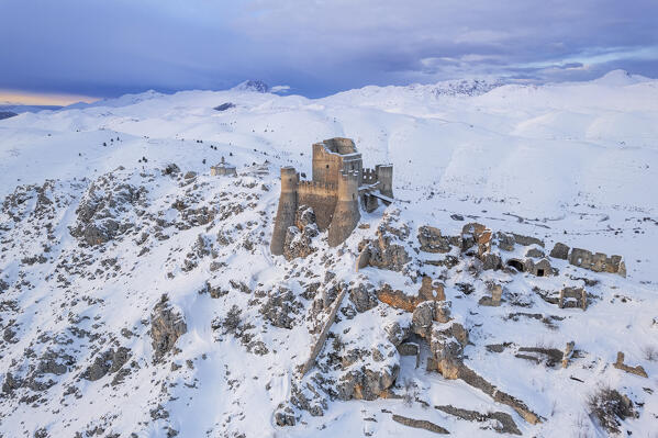 Rocca Calascio castle and Santa Maria della Pietà church in winter with Gran Sasso mountains covered with snow in the background, aerial view, Rocca Calascio, Gran Sasso e Monti della Laga national park, Apennines, L'Aquila province, Abruzzo region, central Italy, Italy, Europe