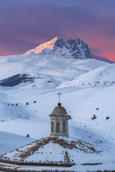 Close-up detail of the snowy roof of the church of Santa Maria della Pietà with Gran Sasso (Corno Grande) in the background at sunset, Rocca Calascio, Gran Sasso e Monti della Laga National Park, Apennines, L'Aquila province, Abruzzo region, central Italy, Italy, Europe