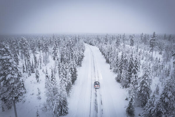 Elevated view of car along the snowy empty road in the frosty wood, Pallas-Yllastunturi National Park, Muonio, Lapland, Finland, Scandinavia, Europe