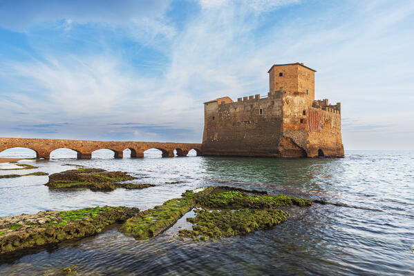 The old narrow bridge leading to the medieval castle of Torre Astura with roman ruins emerging from water in the foreground, Nettuno municipality, Rome province, Latium, Tyrrhenian sea, Italy, Europe