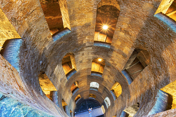 A single person on the bottom of the illuminated Saint Patrik well looks up to the way out, Saint Patrick well, Orvieto, Terni municipality, Umbria region, middle Italy, Italy, Europe