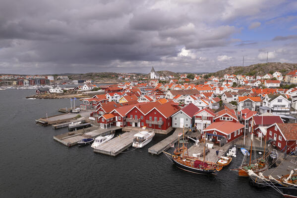 The red and wooden cottages of the picturesque fishing village of Skarhamn by the ocean fjord, Tjorn municipality, Bohuslan, Vastra Gotaland, Sweden, Scandinavia, Europe