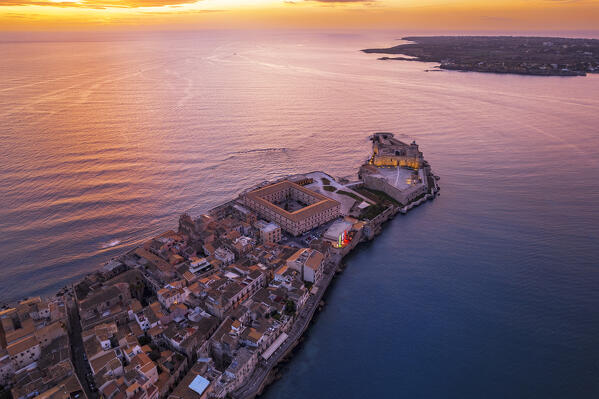 Illuminated old city of Ortygia with the Frederician castle at the top of the peninsula and defensive wall, morning drone picture, Ortigia island, Syracuse, Sicily, South of Italy, Italy, Europe