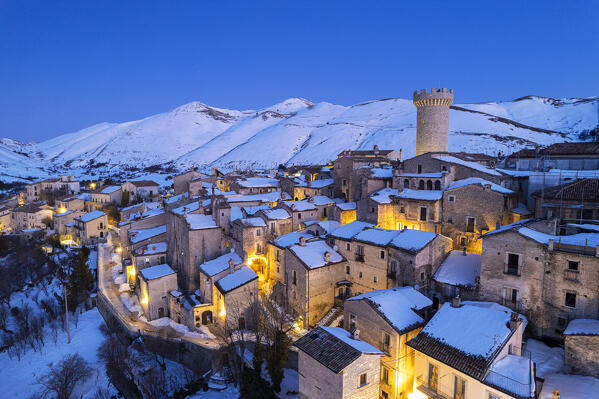 Dusk over the illuminated medieval village of Santo Stefano di Sessanio covered with snow, drone picture, Gran Sasso and Laga Mountains National Park, L'Aquila province, Abruzzo, Apennines, Italy
