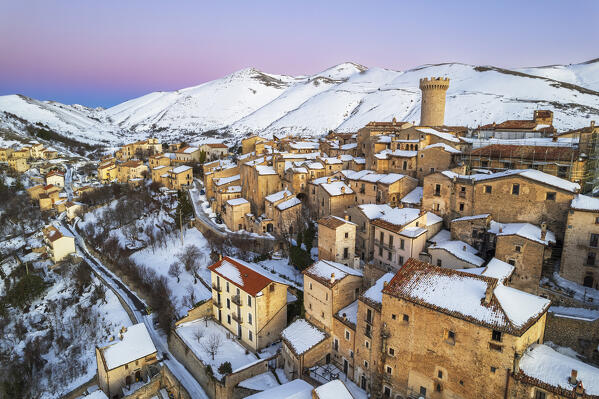 Pink sky frames the ancient mountain village of Santo Stefano di Sessanio in winter, drone view, Gran Sasso and Laga Mountains National Park, L'Aquila province, Abruzzo, Apennines, Italy