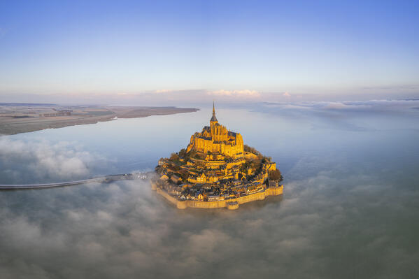 Panoramic aerial view of Mont Saint-Michel in the morning mist surrounded by the high tide at sunrise, UNESCO World Heritage Site, Normandy, Manche, France
