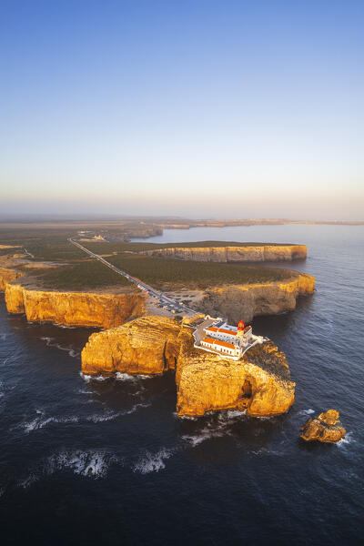Panoramic vertical aerial view of the lighthouse and cliffs at Cape Saint Vincent (Cabo de Sao Vicente) at sunset, Europe's most South-western point, Vila do Bispo municipality, Sagres, Faro district, Algarve, Atlantic Ocean, Portugal, Europe