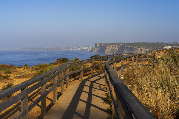 Empty wooden boardwalk above the rocky cliffs of Ponta da Piedade Lagos seen at sunrise, Lagos, Faro district, Algarve, Atlantic Ocean, Portugal, Europe