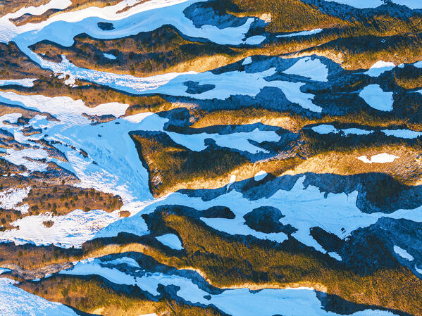 Abstract detail of shapes of mountain ridges with snow, aerial view at sunrise, Campo Imperatore, Gran Sasso e Monti della Laga national park, L'Aquila, Abruzzo, Apennines, Italy