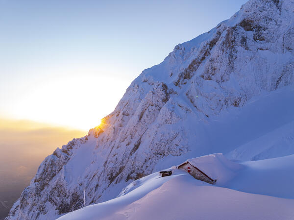 Snowy Carlo Franchetti mountain hut in the frozen landscape at sunrise, aerial picture, Gran Sasso e Monti della Laga national park, Pietracamela, Teramo, Abruzzo, Apennines, Italy