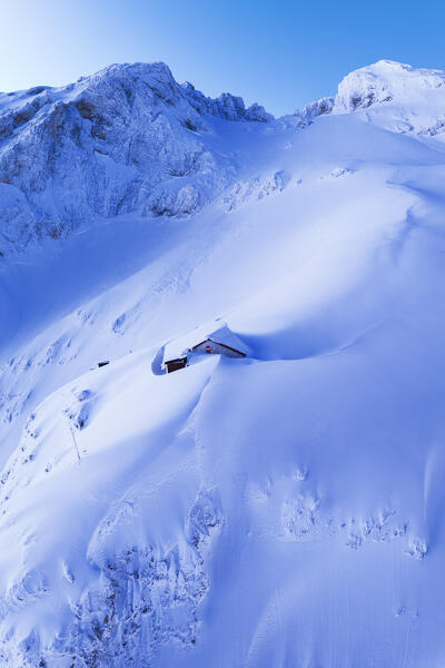 Solitary mountain hut in deep snow at dusk, aerial picture, Franchetti hut, Gran Sasso e Monti della Laga national park, Pietracamela, Teramo, Abruzzo, Apennines, Italy