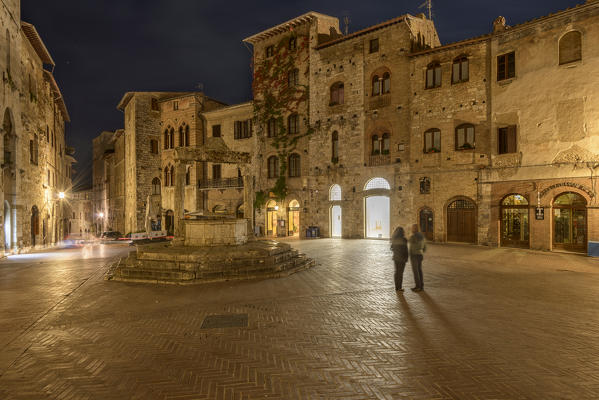 Tourists in the square of San Gimignano at night. Italy, Tuscany, Siena district. 