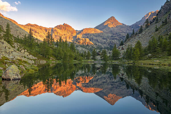 The peaks of the Mont Avic park are reflected in the Cornu lake at dawn. Mont Avic, Aosta province, Valle D'Aosta, Italy, Europe.