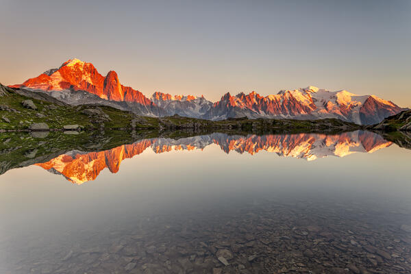 Little alpine lake, reflecting the Mont Blanc massif, in the sunset. Lake Chesery, Mount Blanc, France. 