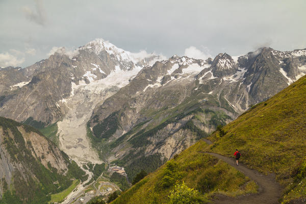 Hiker go on a trail in Val Ferret. Bonatti Hut, Ferret Valley, Courmayeur, Aosta Valley, Italy, Europe