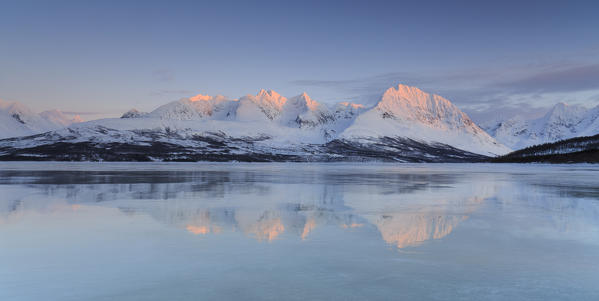 The snow covered Lyngen Alps reflecting on the icy waters, Lyngen Alps, Norway