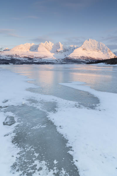 The snow covered Lyngen Alps reflecting on the icy waters, Lyngen Alps, Norway