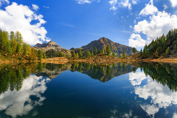 Mountains reflected into Lago dei Pozzoi in autumn, Valle di Campo, Valle Maggia, Canton Ticino, Switzerland, Europe