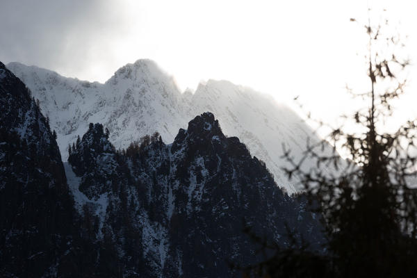 Sunset light effect behind the iced peaks of Val Bregaglia, Canton Grisons, Switzerland, Europe