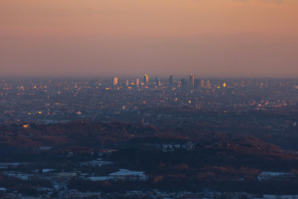 Milan skyline at sunset from the hills above Como, Como, Lombardy, Italy