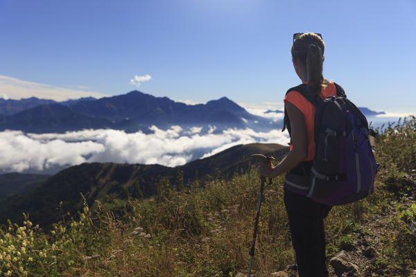 Hiker on the path leading to the summit of Mount San Primo looking at Grigne Group, Triangolo Lariano, Bellagio, Province of Como, Lombardy, Italy