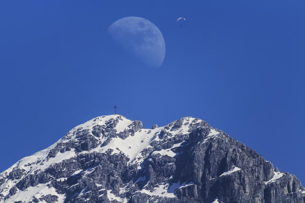 Summit of Monte Resegone mountains with half mooon and a paraglider in the sky, Lecco, Province of Lecco, Italy, Lombardy