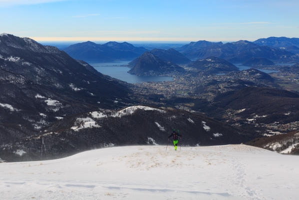 Hiker reaching Capanna monte Bar refuce with Lugano Lake in the background, val colla, canton ticino, switzerland, europe