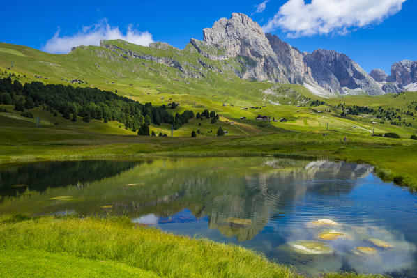 Seceda peak reflected in lake Lech Sant, Odle range, Dolomites, Italy