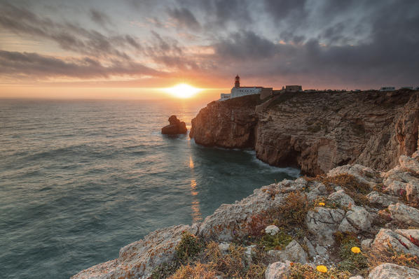Sunset frames the lighthouse overlooking the Atlantic Ocean Cabo De Sao Vicente Sagres Algarve Portugal Europe