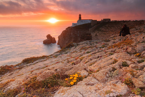 Sunset frames the lighthouse overlooking the Atlantic Ocean Cabo De Sao Vicente Sagres Algarve Portugal Europe