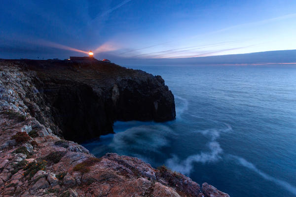 Sunset frames the lighthouse overlooking the Atlantic Ocean Cabo De Sao Vicente Sagres Algarve Portugal Europe