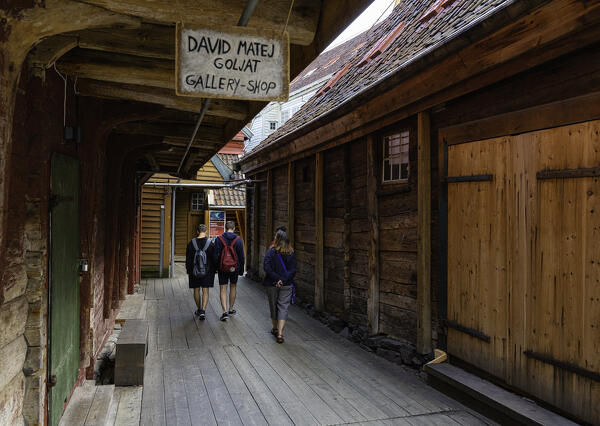 Tourist admiring the unique Bryggen's quarter architecture, Unesco Site. Bergen, Norway. - 
