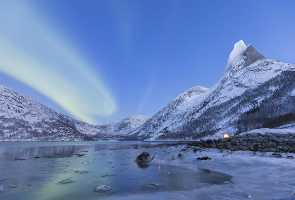 Northern lights over frozen sea in a Tysfjord bay and near the Norway's national mountains granitic snowy peak called Stetind,tysfjord Nordland county Norway Europe