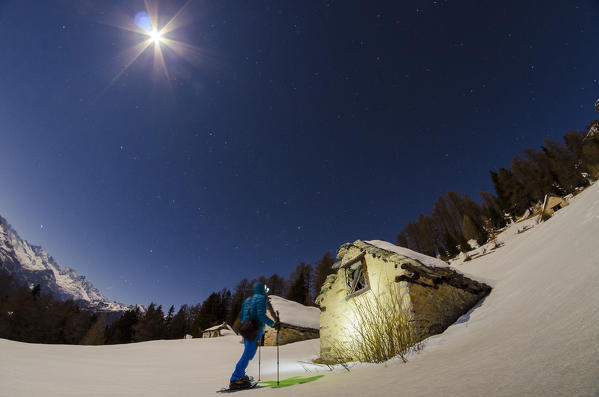 Hiker in front of an house at Alpe Il Rono (Divedro valley, Ossola, Piedmont, Italian alps)