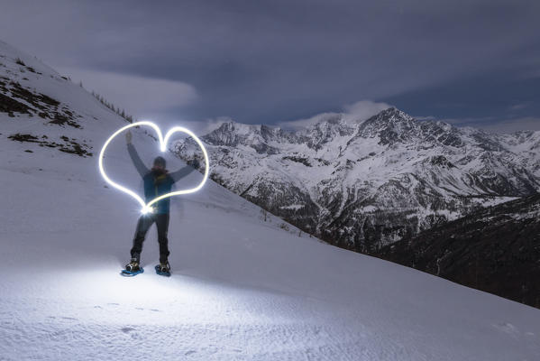 Hiker play with the torches at Monscera pass in night time, Bognanco valley, Ossola, Piedmont, Italian alps, italy
